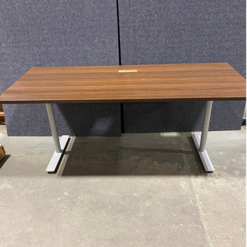 Wooden desk with white legs against a gray wall.